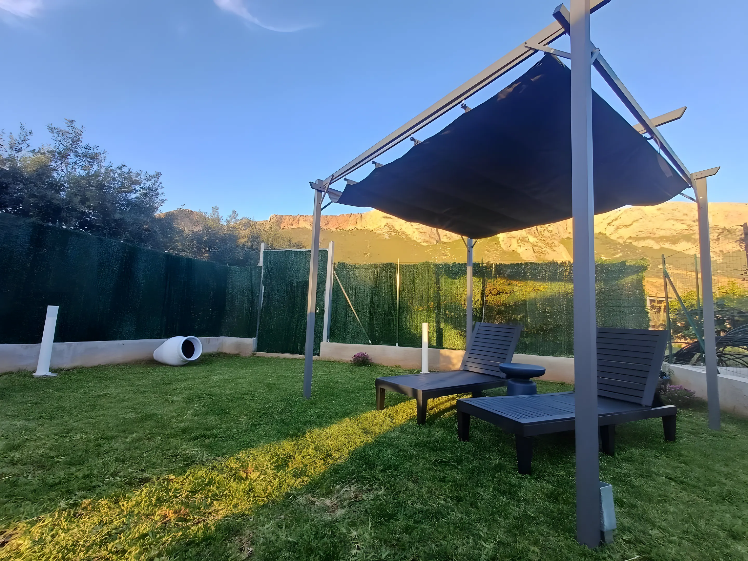 Giardino con pergola ombreggiata e lettini
