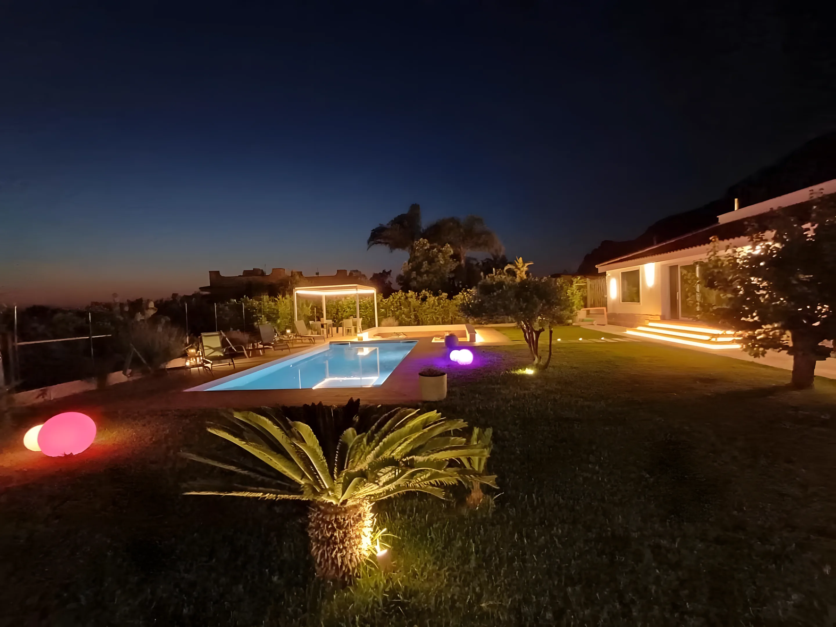 Villa e piscina illuminate di notte con luci colorate