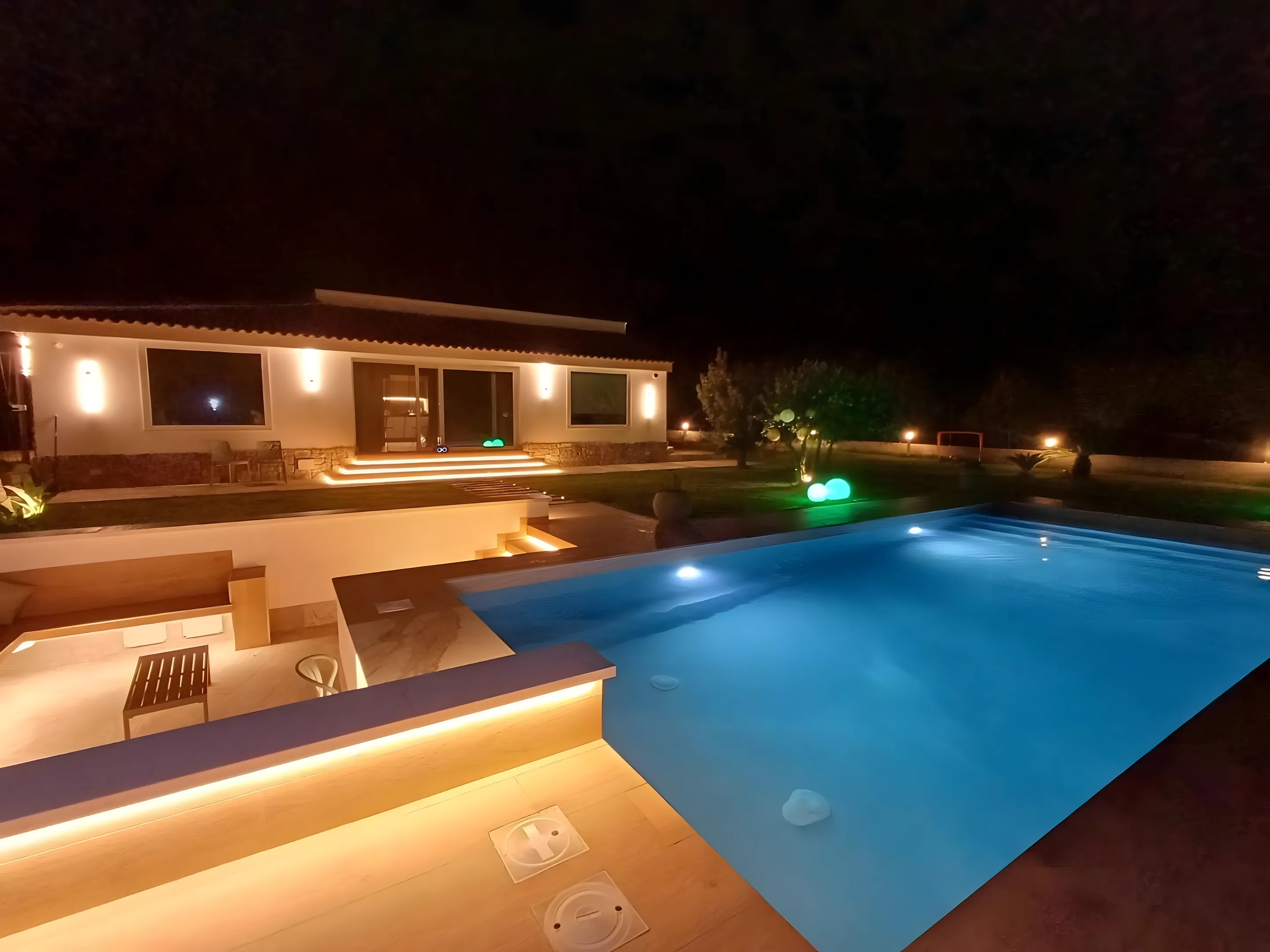 Villa con piscina illuminata nella notte