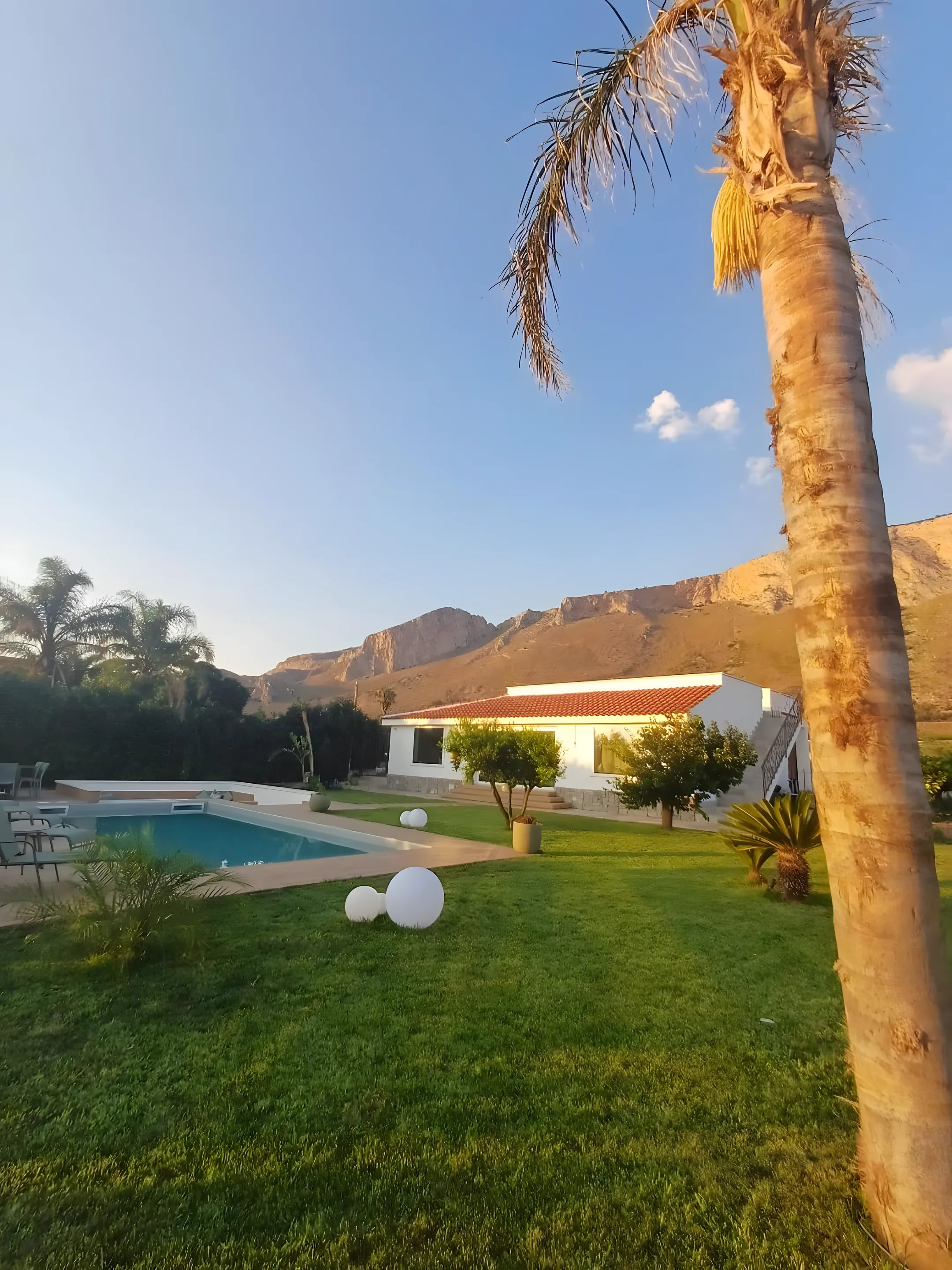 La villa al tramonto tra palme e montagne