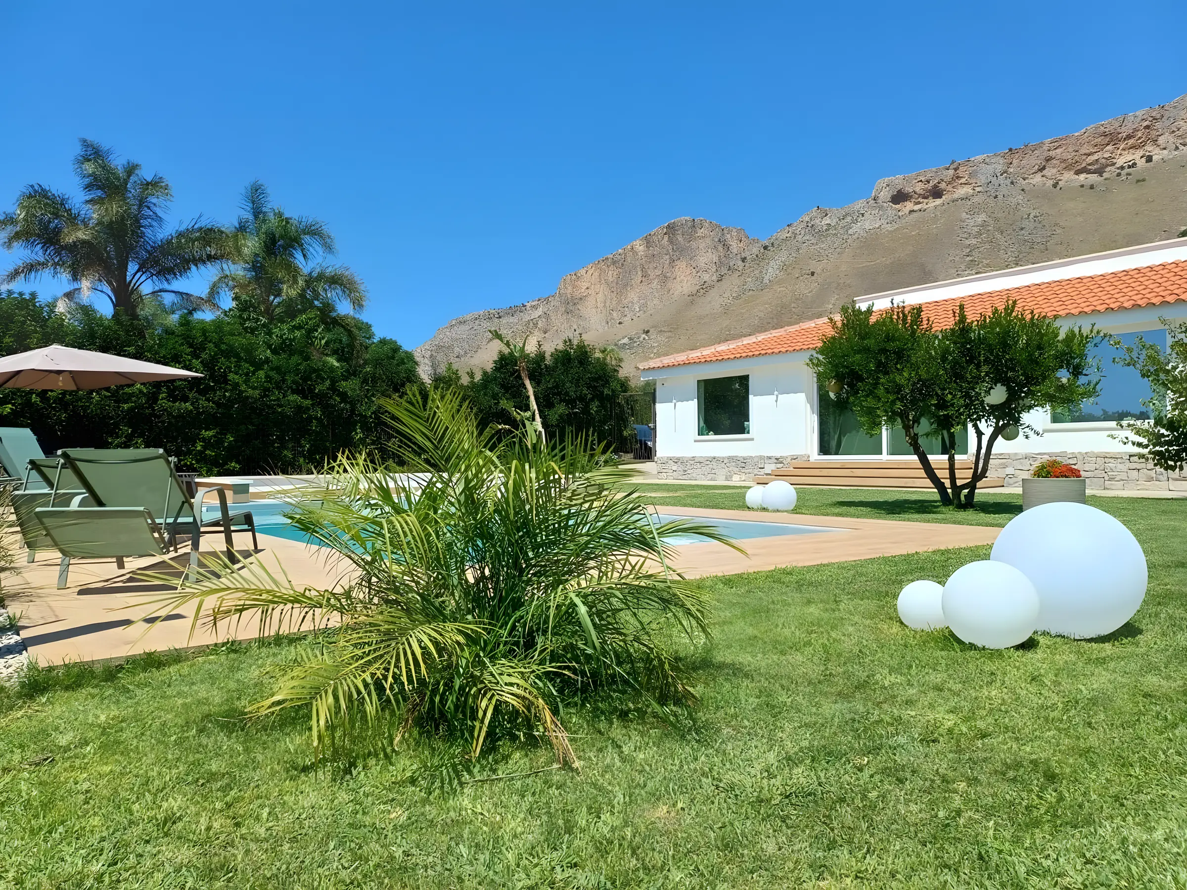 Villa con piscina e palma sotto la montagna