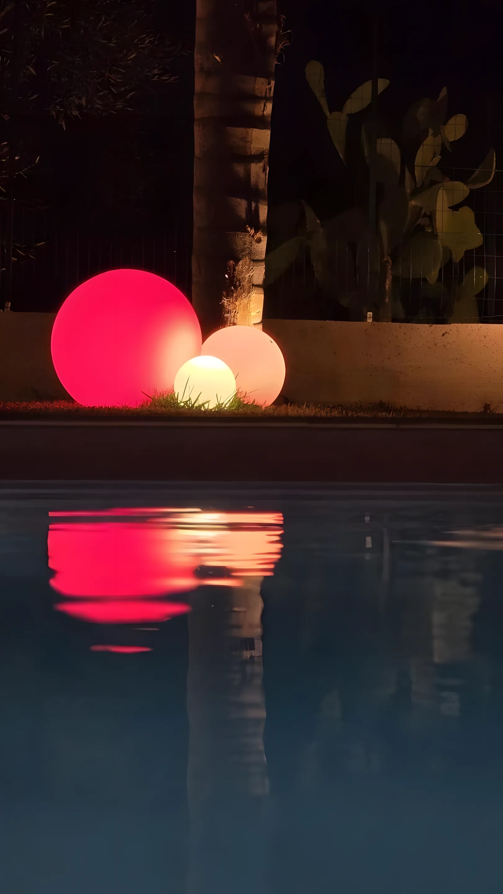 Piscina notturna con sfere luminose colorate