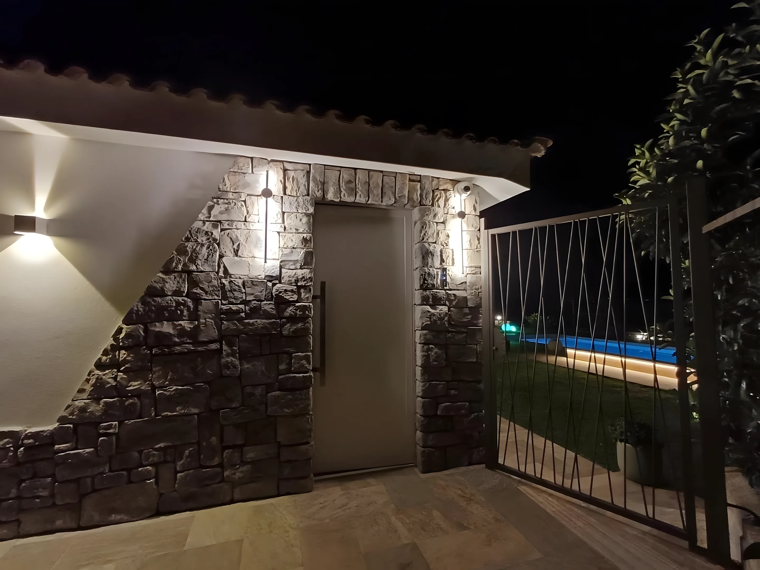 Muro esterno in pietra con luci nella notte