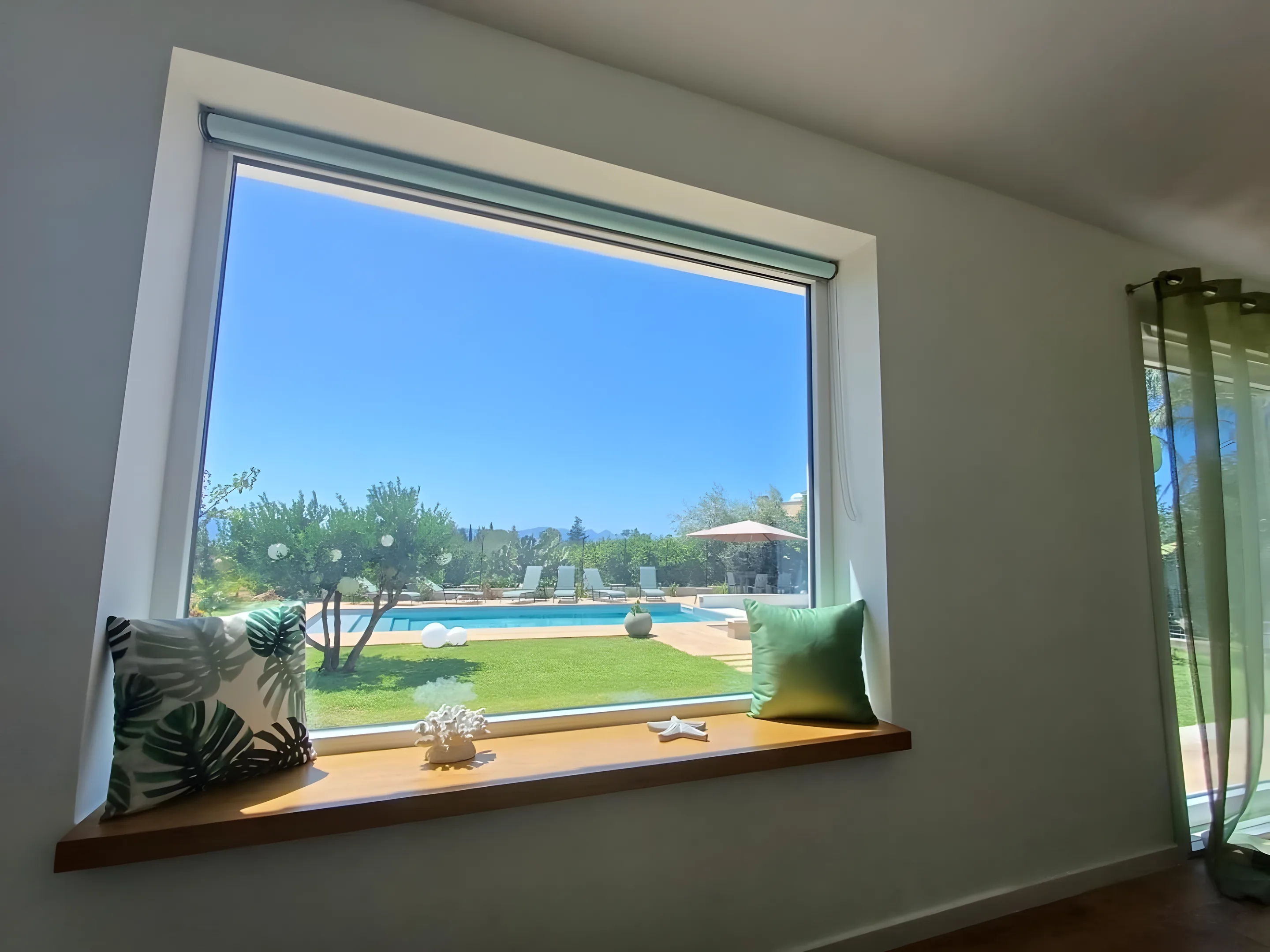 Vetrata panoramica con cuscini affacciata sulla piscina