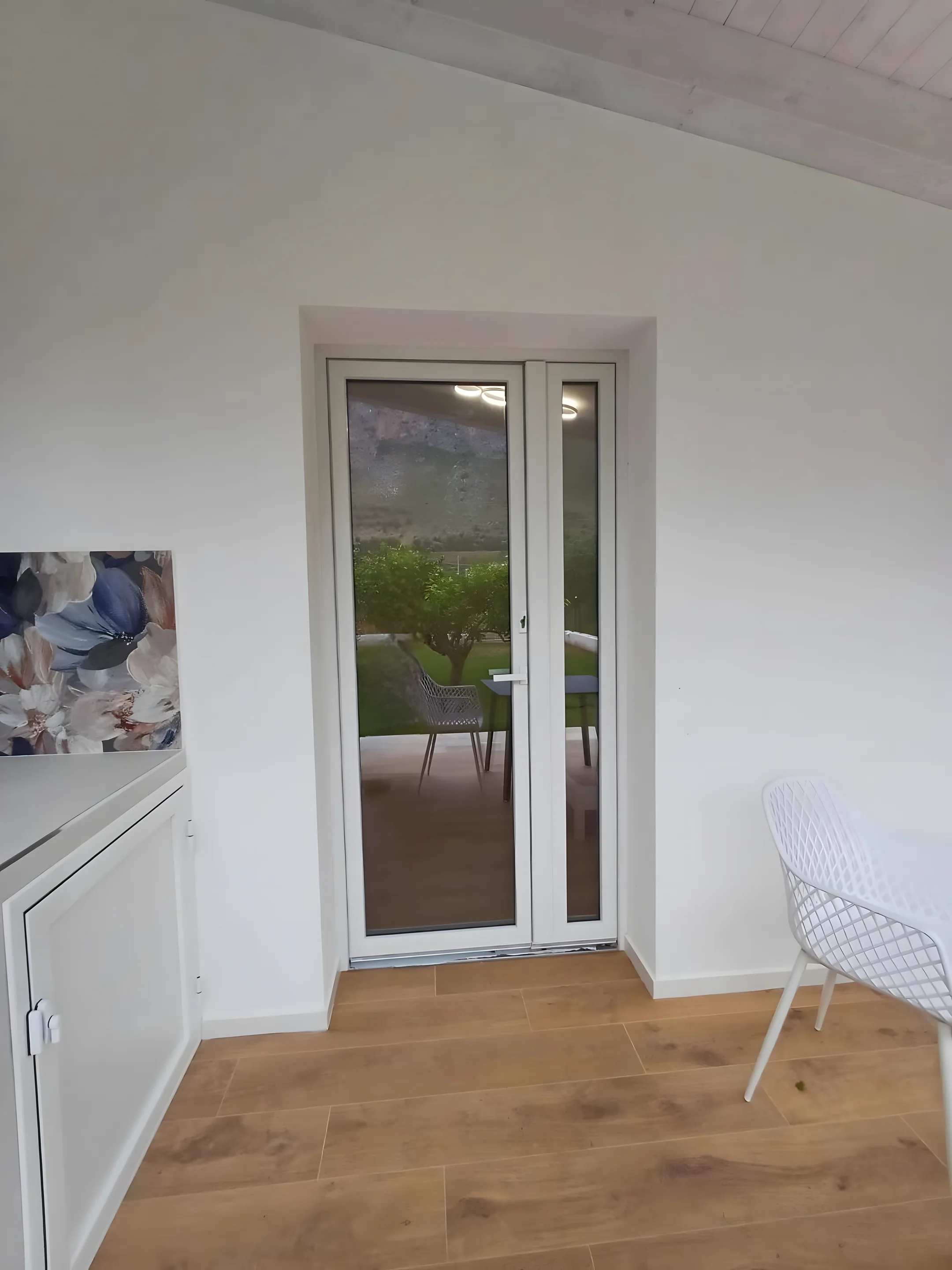 Camera della dépendance con portafinestra sul giardino