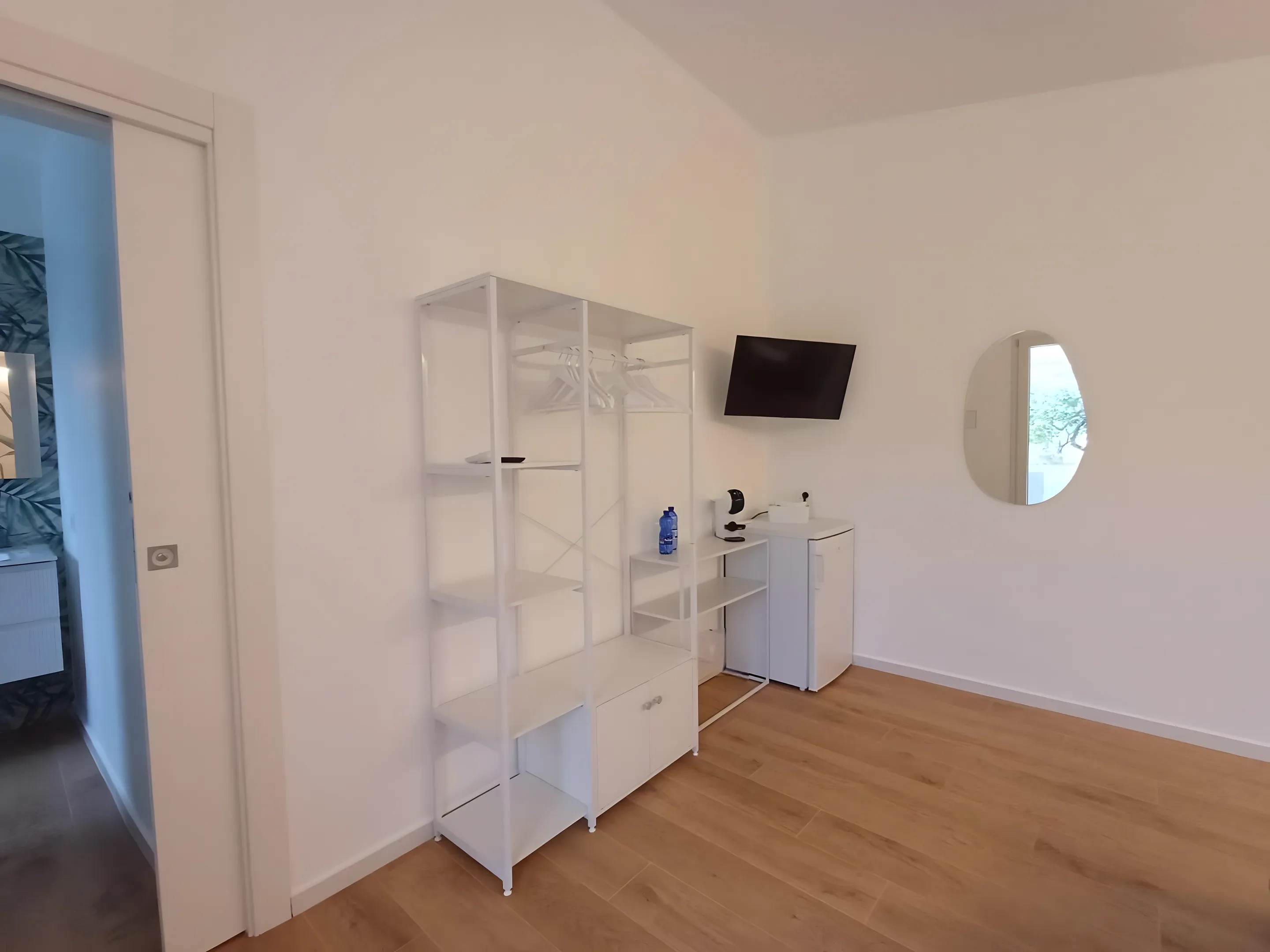 Zona notte della dépendance con mensola, mini-bar e TV