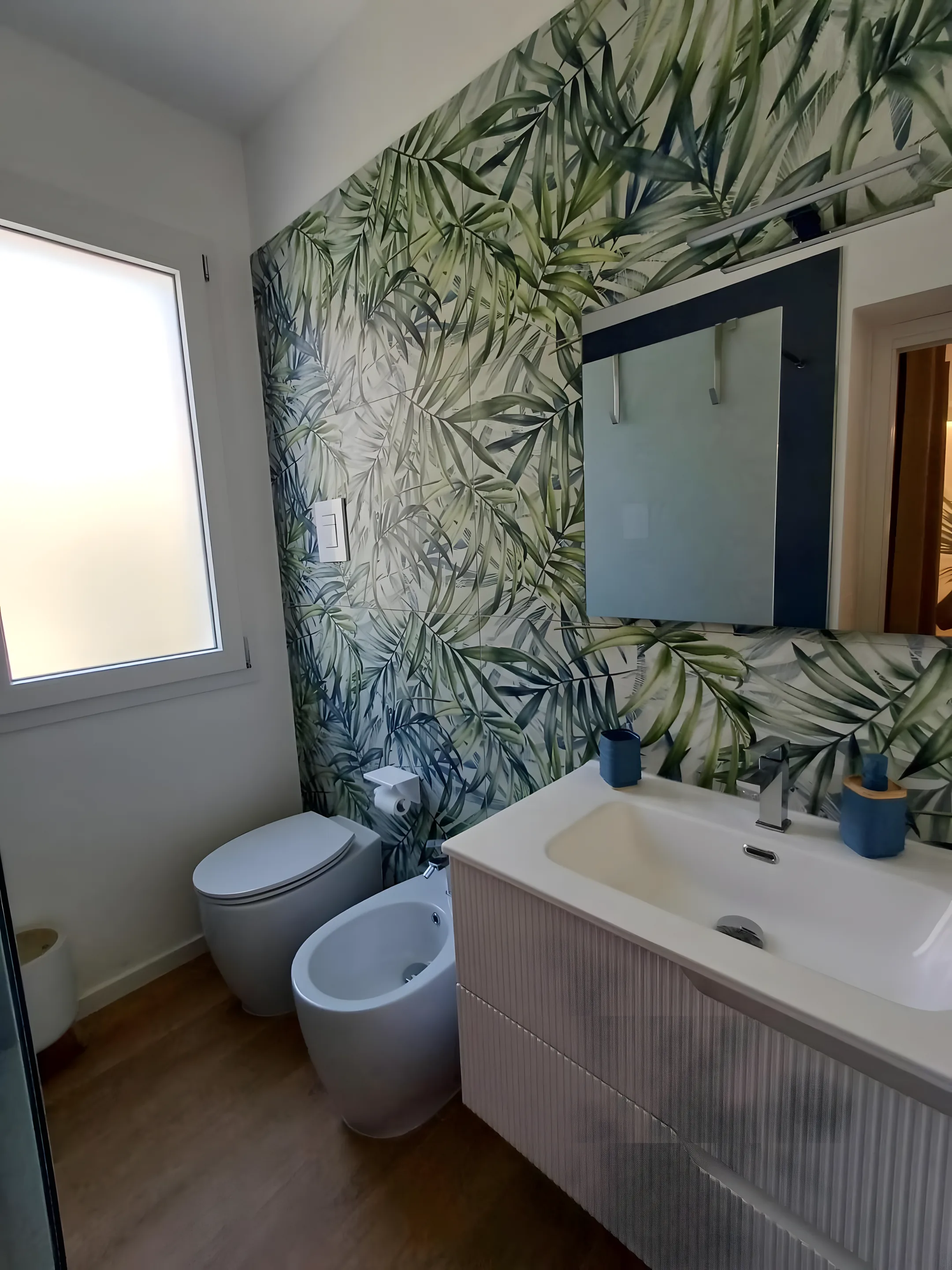 Bagno della dépendance con carta da parati a palme